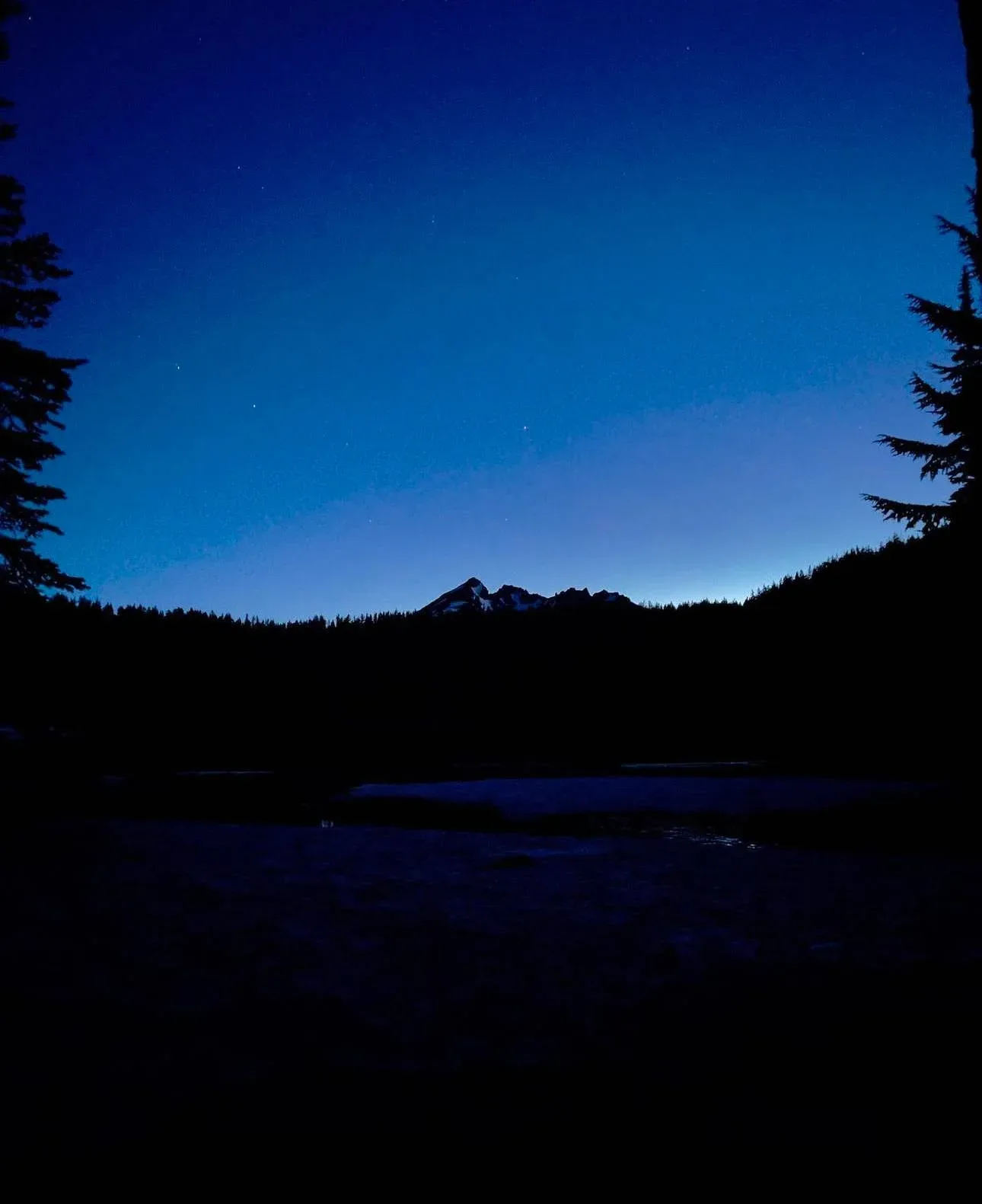 Broken Top at twilight above a mountain lake.